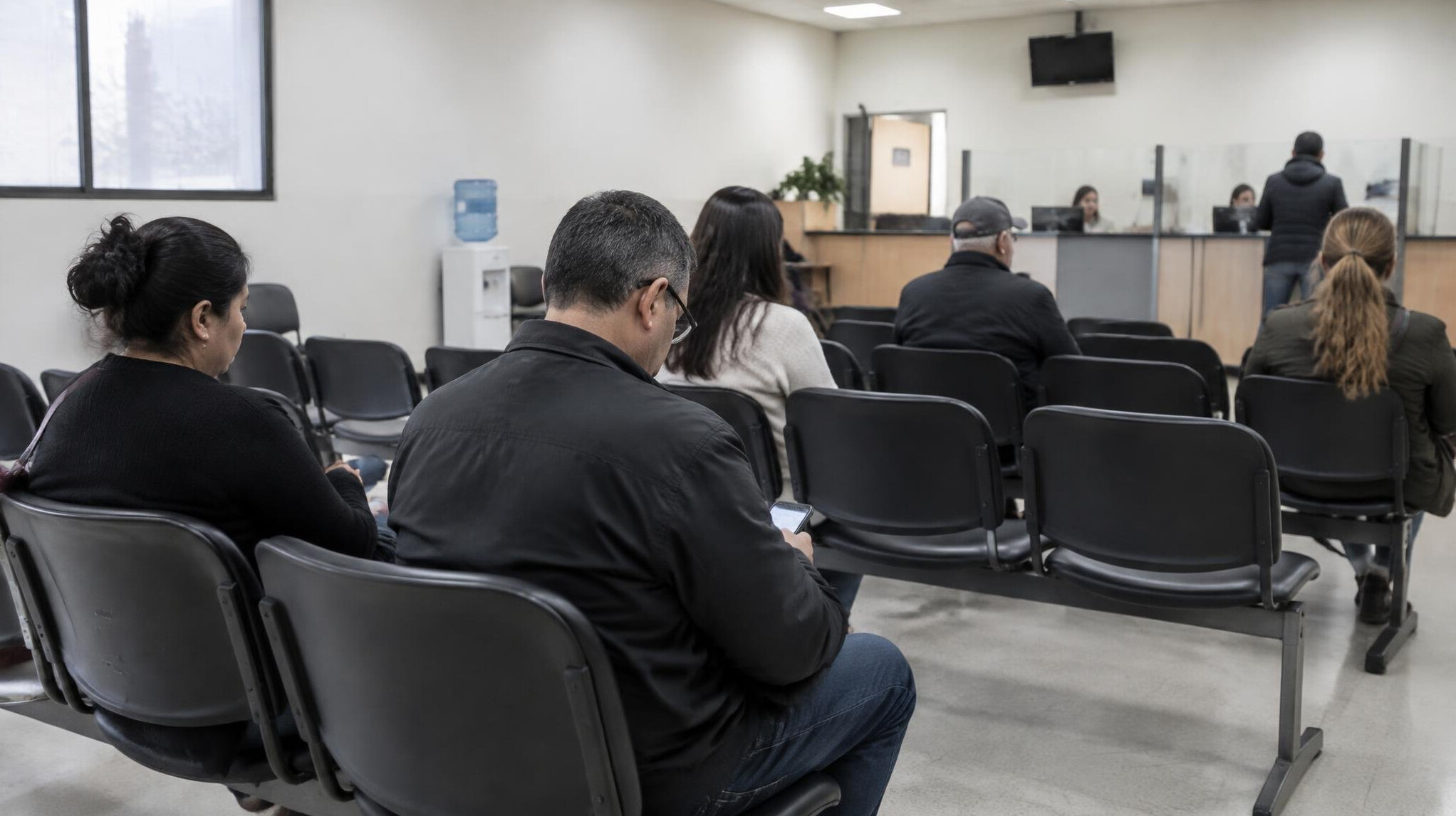 People sitting in a waiting room of a public service office