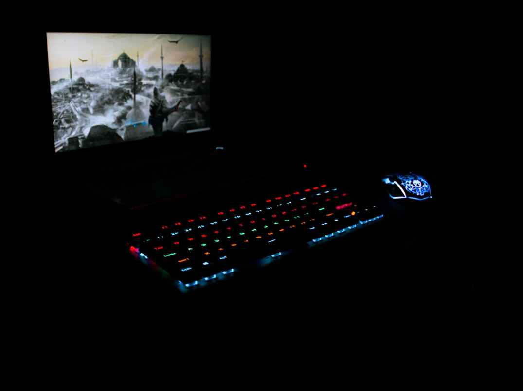 Person typing on a laptop at night with only the screen lighting the room